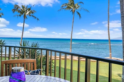 A balcony with table and chairs overlooking palms and ocean, the perfect spot for morning coffee or sunset wine.