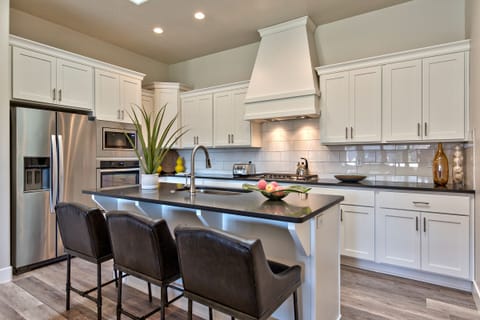 Kitchen View - The Kitchen is fully stocked with all the dishes, cookware, baking pans, and cutlery you will need for meal preparations and includes stainless steel appliances and granite counter tops.