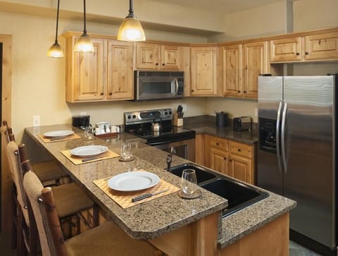 The fully-equipped kitchen features granite countertops and a breakfast bar