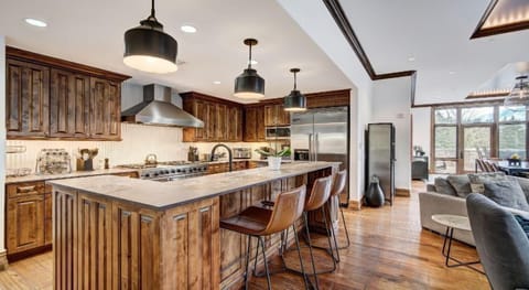 The gourmet kitchen is a chef's dream, featuring rich wood cabinetry, top-of-the-line appliances, and a welcoming island bar for casual dining.