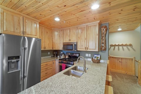 Efficient kitchen with gas range and breakfast bar. 