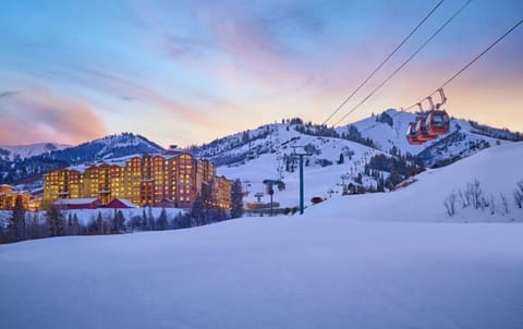 Witness a serene evening glow over snow-covered hills as the lifts operate, inviting you to enjoy a magical mountain retreat.