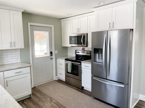 Kitchen stove area with full stove and refrigerator