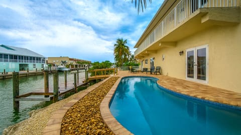 Charming canal-side home with private dock and lush tropical landscaping.