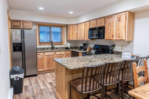 The well-laid-out kitchen features all the amenities needed to make meals in the comfort of the home with lovely granite countertops, ample cabinet space, and a spacious kitchen island with bar stool seating for four.