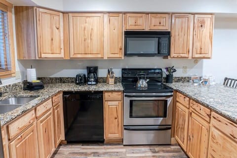 The well-laid-out kitchen features all the amenities needed to make meals in the comfort of the home with lovely granite countertops, ample cabinet space, and a spacious kitchen island with bar stool seating for four.