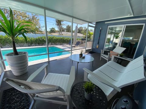 The lanai looks upon the private heated pool situated in a tropical landscape