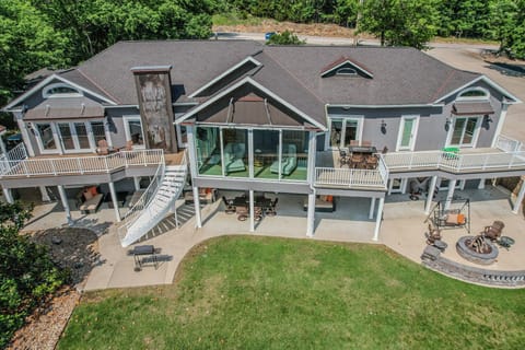 Stunning lakefront home with expansive decks, outdoor seating, and fire pit.