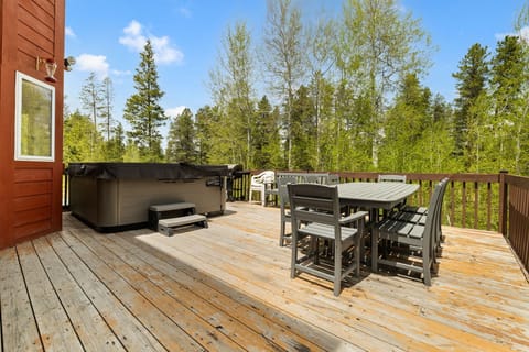 Deck with large hot tub and outdoor dining. 