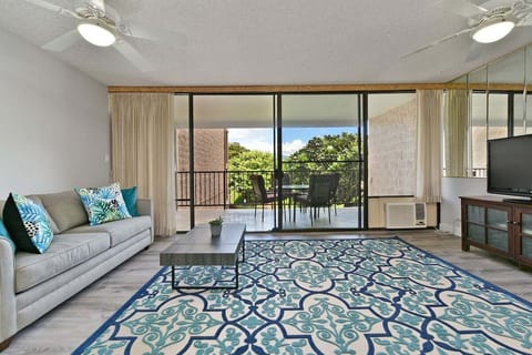 Bright living room with sleeper sofa and private lanai access.