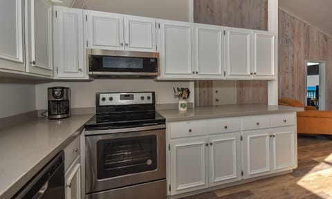 Kitchen with gray countertops, stainless steel appliances, and white cabinets