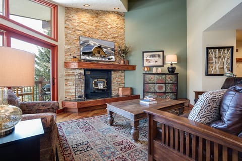 Sink into plush leather seating by your crackling fireplace, where rustic charm meets mountain elegance in this inviting living space.