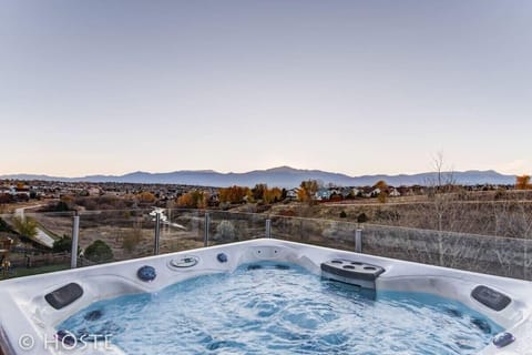 Bubbling hot tub positioned to face sweeping mountain and valley views. Sink into the warm water while the landscape stretches out in front of you, an inviting spot to unwind as the sky shifts colors over the distant ridgelines.