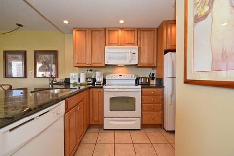 Functional kitchen with white appliances and wooden cabinets