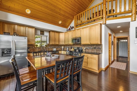Spacious kitchen with granite counters, wood cabinetry, and a lofted dining layout perfect for hosting.