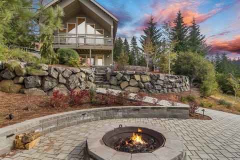 Vista Ridge - VR 365 - Twilight firepit lounge framed by terraced stone walls and the glowing timber lodge above