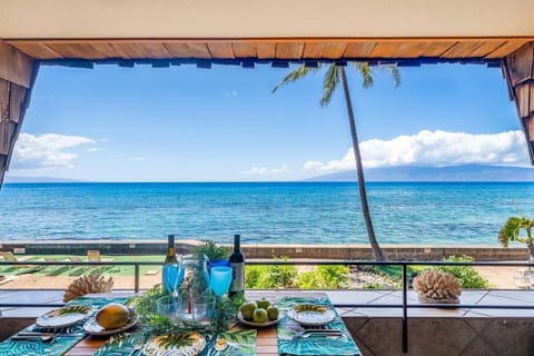 Oceanfront lanai with dining table, tropical decor, and Pacific Ocean views.
