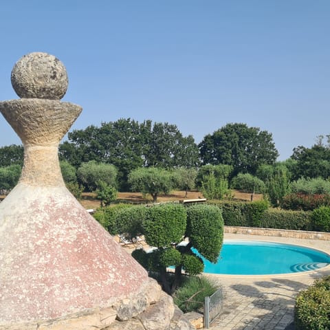 The swimming pool is circular in theme with the cones of the trullo
