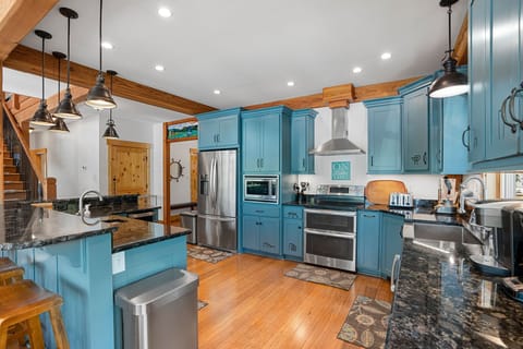Kitchen with double oven, two sinks, microwave and full-sized fridge