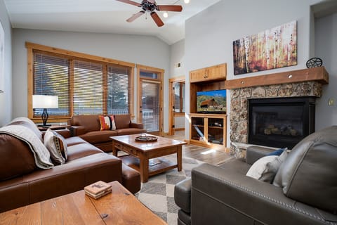 Sink into plush leather seating by your cozy stone fireplace, where warm wood accents and mountain views create the perfect retreat.