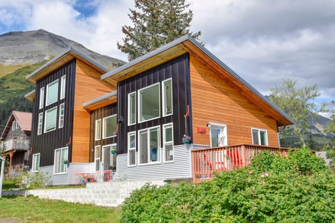 Exterior facing south with deck off East Room and outdoor patio off kitchen