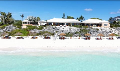 view from beach of 9 tiki umbrellas and 18 chaise lounges