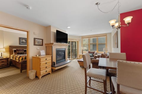 Relax in your spacious suite featuring a cozy fireplace, dining area, and separate bedroom - perfect for unwinding after mountain adventures.