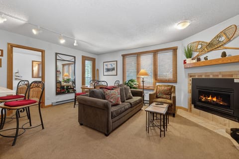Relax by your glowing fireplace on cozy seating, perfect after a day exploring. The open layout, rustic accents, and warm lighting create an inviting retreat.