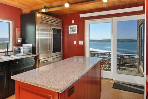 Kitchen leads out to a deck with a table and the grill.