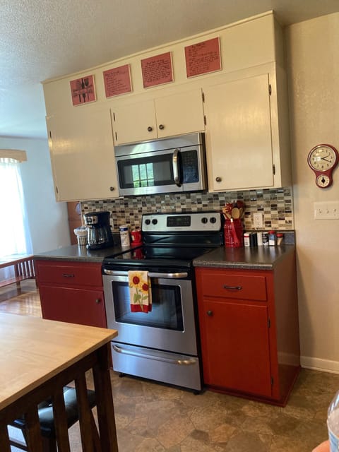 Complete kitchen with range, microwave and coffee pot with coffee provided.