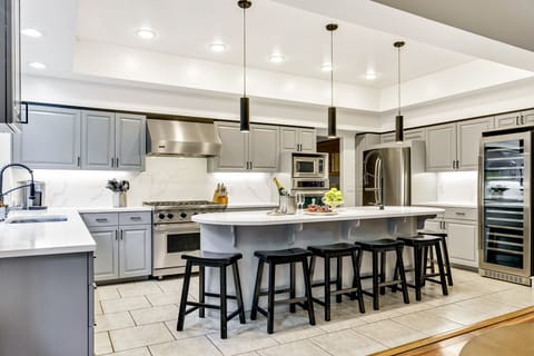 Kitchen has granite countertops, a wine cooler and island.
