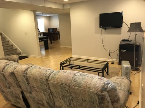 finished walk out basement  w recliner, couch and air hockey & foosball tables