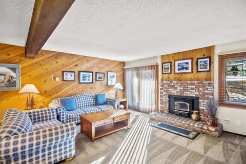Living room with a wood burning fireplace and access to the deck