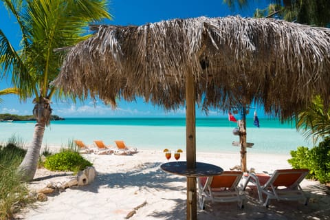 Beachfront palapa with lounge chairs