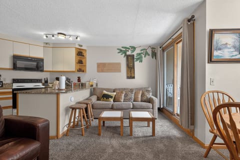 Unwind in your inviting living space with cozy seating, a fully equipped kitchen, and sliding doors opening to your private escape. Rustic touches and mountain charm welcome you home.