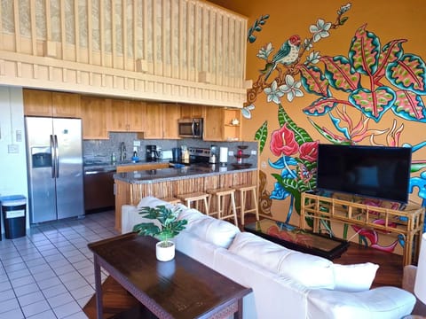 Living room with mural, TV &leather couch that turns into a queen bed .