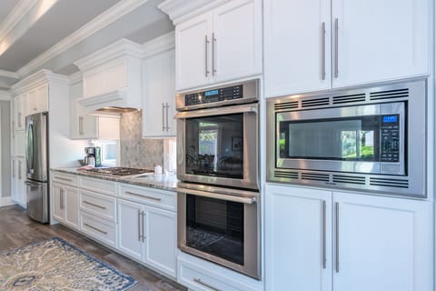 Kitchen features high end appliances including double oven and gas cooktop.