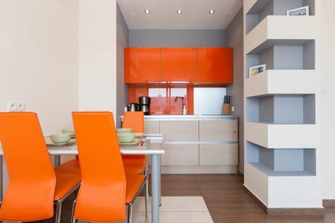he modern kitchen with open shelving and bright orange cabinets, designed to provide functionality while keeping a contemporary style.