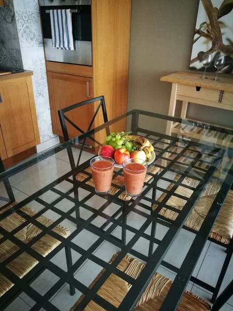 The dining table decorated with flowers and a candle, with a plant and decorative painting on the wall, creating a cozy ambiance.