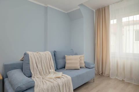A cozy seating area with a grey sofa and neutral pillows. Soft lighting adds a warm and inviting touch.