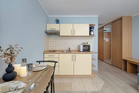 A stylish decor arrangement on the dining table, featuring candles and a vase. This touch creates a welcoming dining setup.