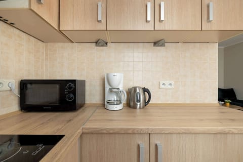 A kitchenette with bright furniture and white goods such as a microwave and tea and coffee making facilities.