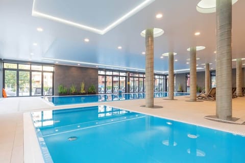 A large bright space where there is an indoor swimming pool.