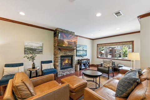 Sink into plush leather seating and gather around the warm stone fireplace, where thoughtful coastal artwork and abundant natural light create your perfect mountain retreat.
