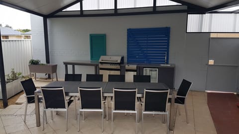 Patio with 10 chairs dining table, BBQ, outdoor kitchen and bar fridge 