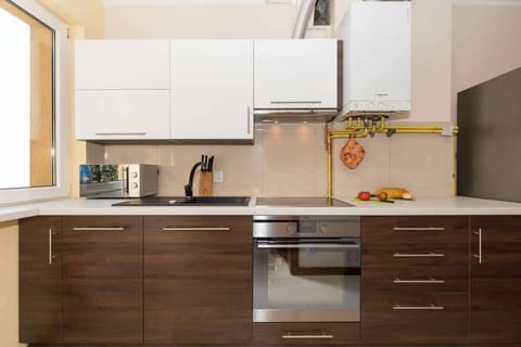 Kitchen with brown and white cabinets. The kitchen has an oven, hob and microwave. 