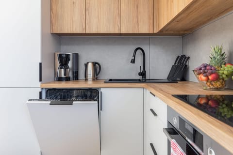 A bright kitchen-dining space with a modern wooden dining table set with turquoise plates and glasses, perfect for a family meal.