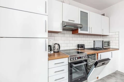 Another view of the kitchen, showcasing the dining area from a different angle, with the same modern, clean design and a focus on the open plan layout.