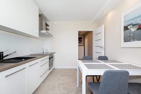 A dining area with a table and four chairs, adjacent to the kitchen, designed for meals and gatherings.
