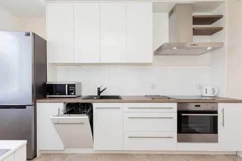 A modern kitchen with white cabinets, built-in appliances, and a sleek, clean design suitable for everyday use.
